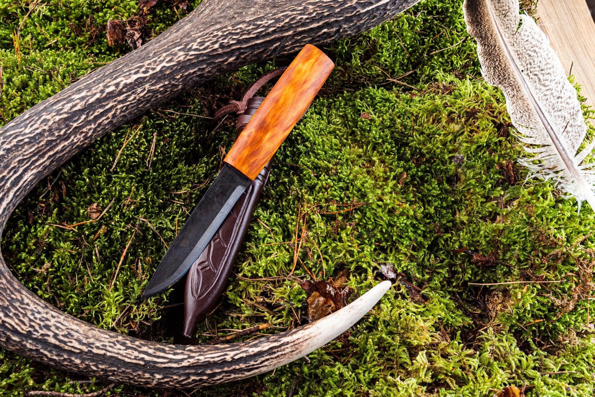 Hunting knife with wood handle on a leather sheath