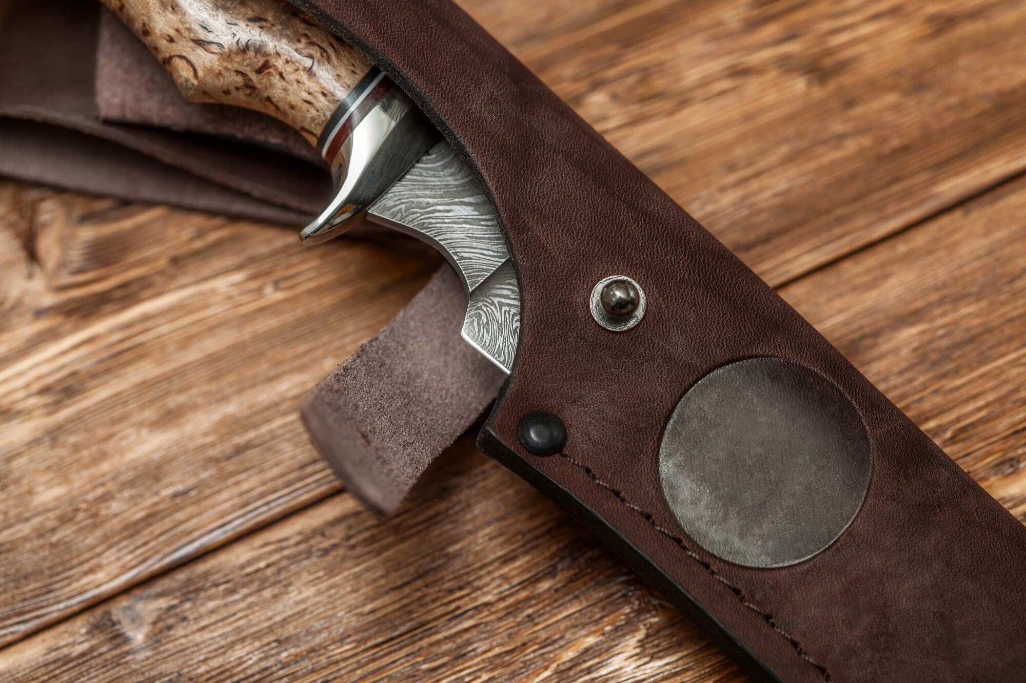 Hunting knife with wood handle on a wooden surface